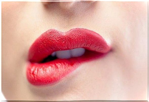 Woman with red lipstick who bites her lip and this can cause mistrust