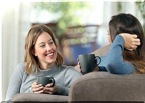 Girlfriends talking with a cup of coffee in their hands