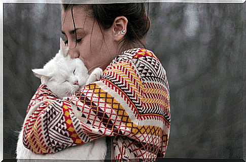 A woman hugs a cat