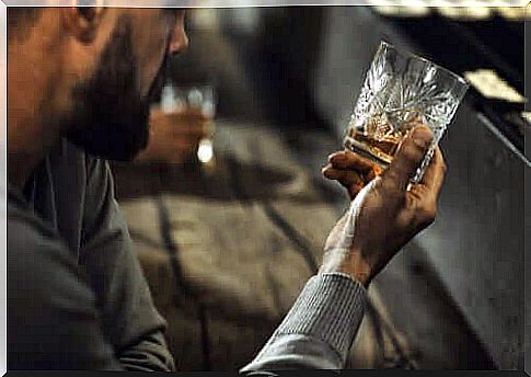 A man looks at an almost empty glass of alcohol