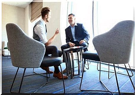 Two men are sitting in an office talking