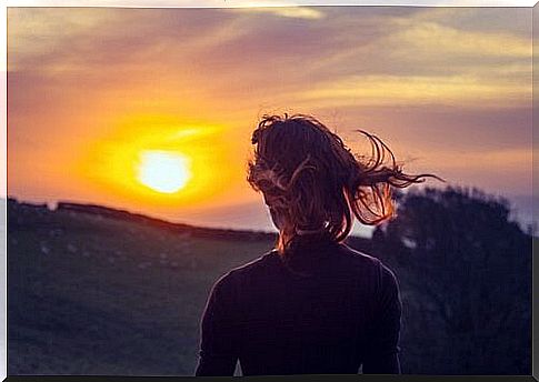 Woman looks at the sun and knows: living in the present is important