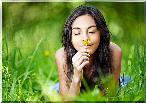 Woman smells flower and knows: living in the present is important