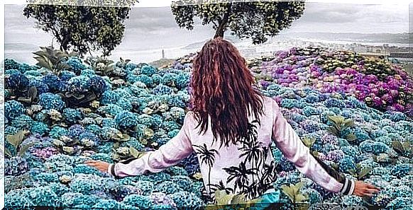 Woman between the blue and purple flowers