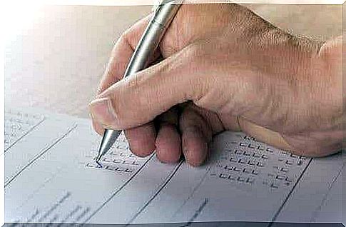 An image of a hand ticking boxes with a ballpoint pen